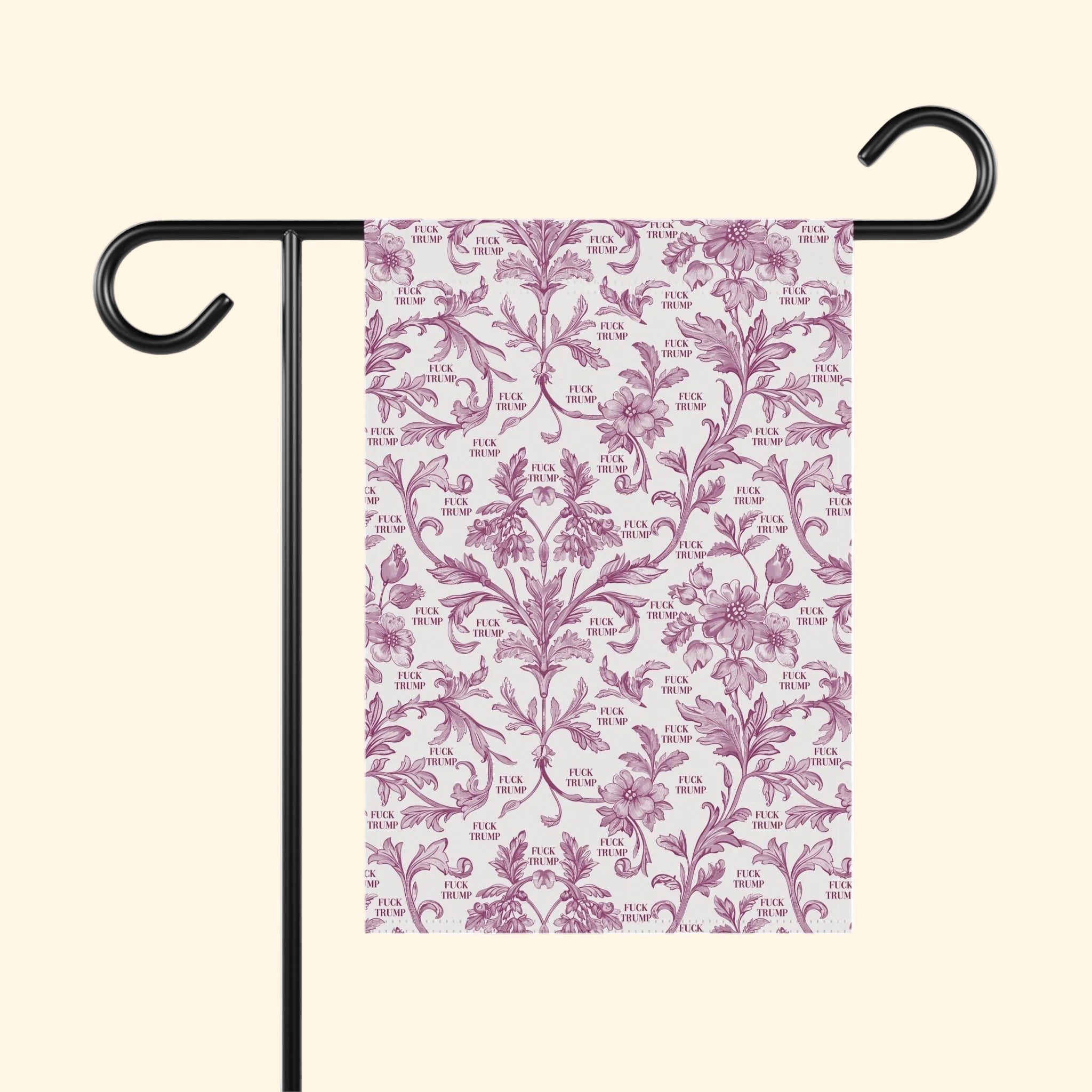 Decorative garden flag with pink floral pattern on a white background, attached to a black flagpole.