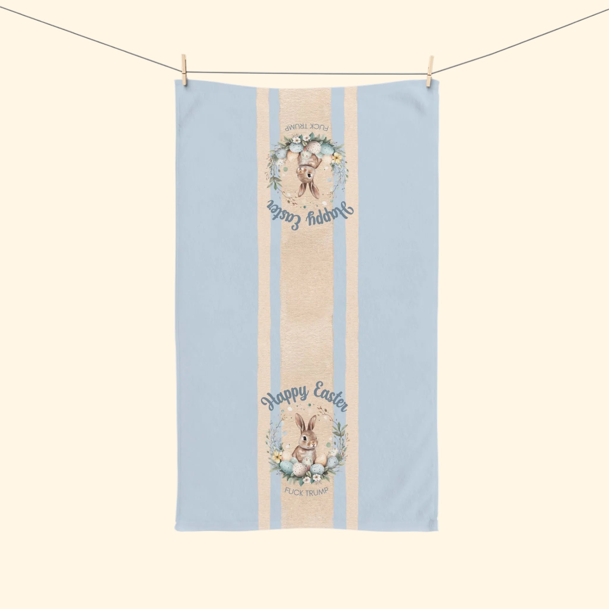 Tea towel with Easter design featuring bunnies and floral elements on a light blue background.