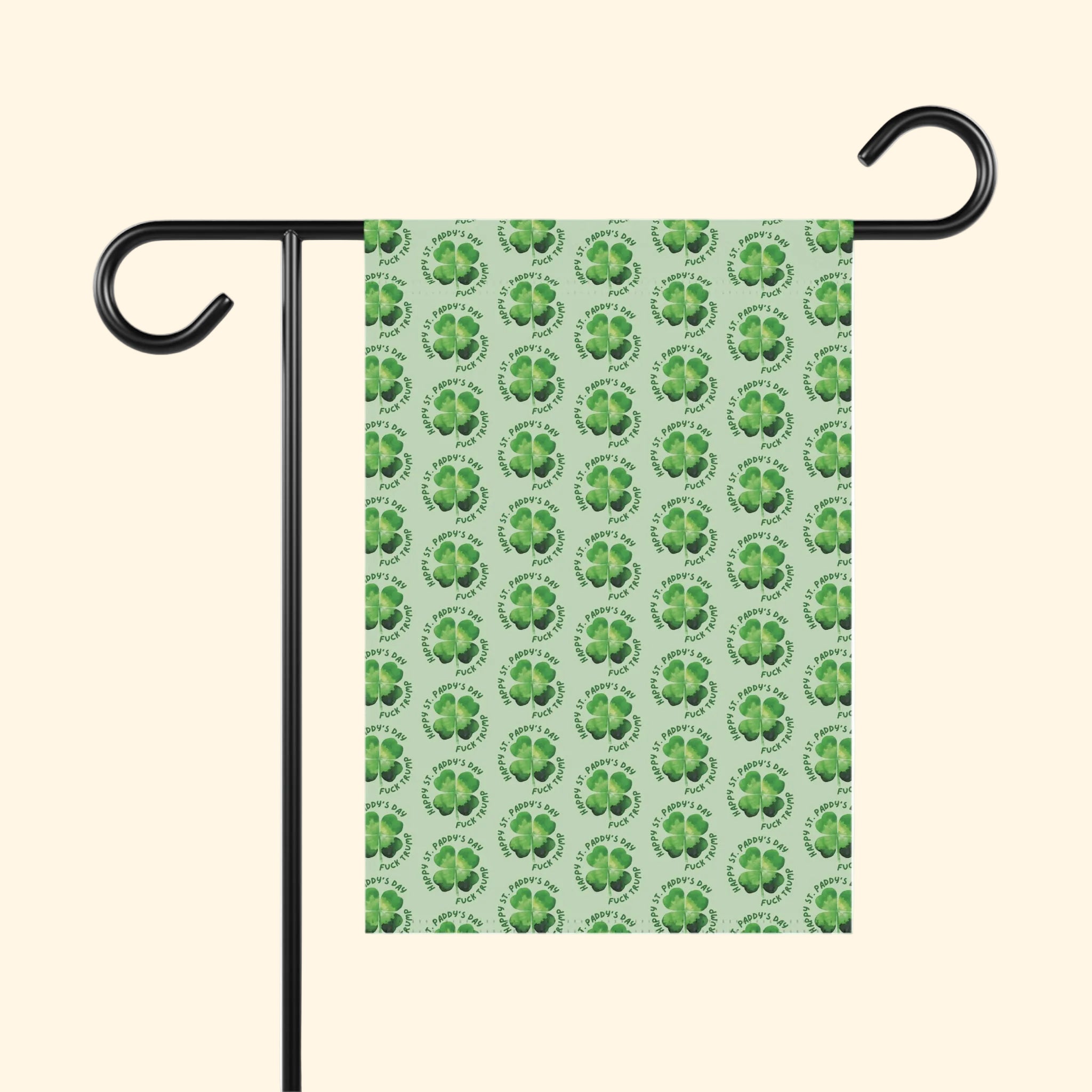 Garden flag with green shamrock pattern on a white background, attached to a black flagpole.