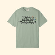 Green t-shirt with 'Holiday Lights and Human Rights' text on a white background