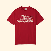 Red t-shirt with 'Holiday Lights and Human Rights' text on a white background