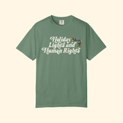Green t-shirt with 'Holiday Lights and Human Rights' text on a white background