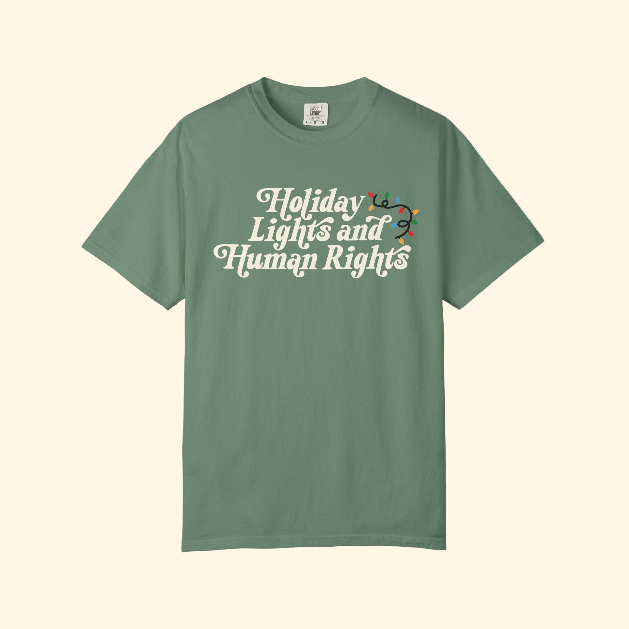 Green t-shirt with 'Holiday Lights and Human Rights' text on a white background