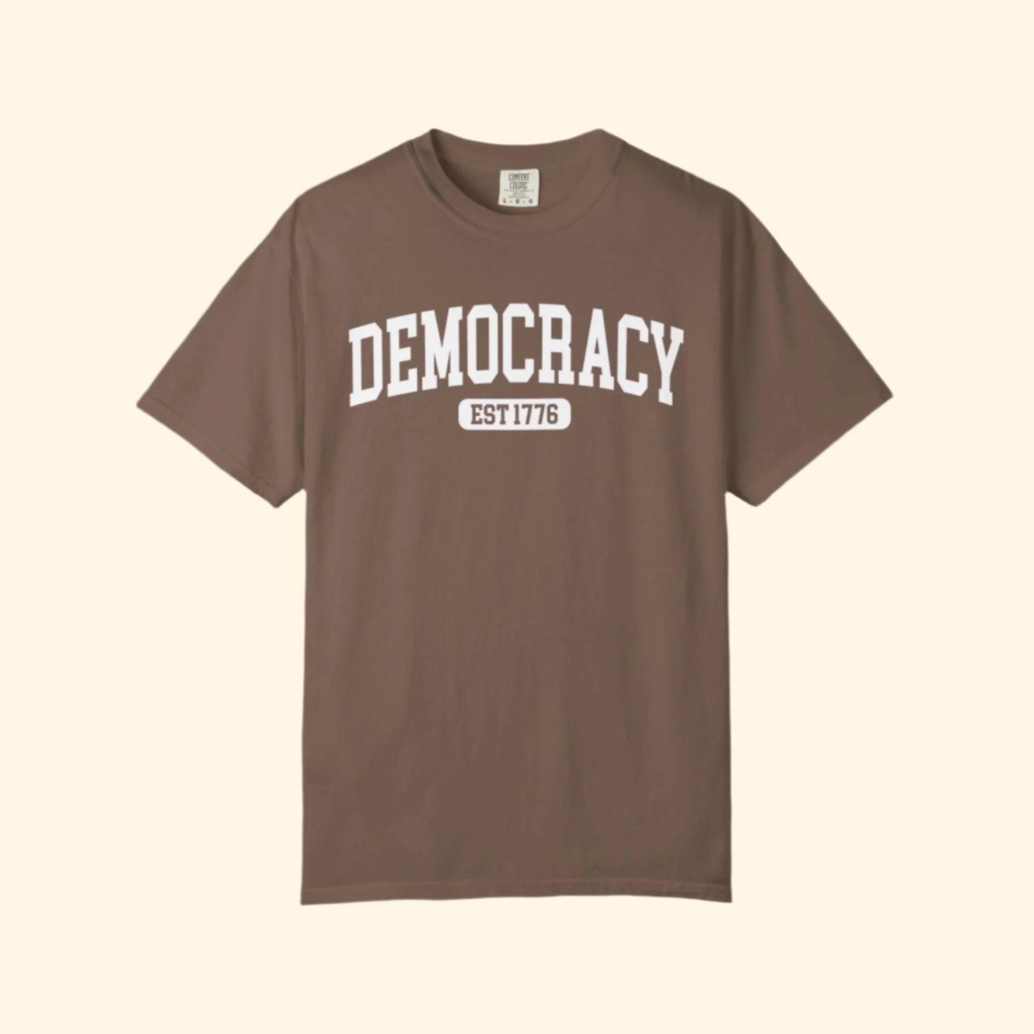 Brown t-shirt with 'DEMOCRACY EST 1776' text on a white background