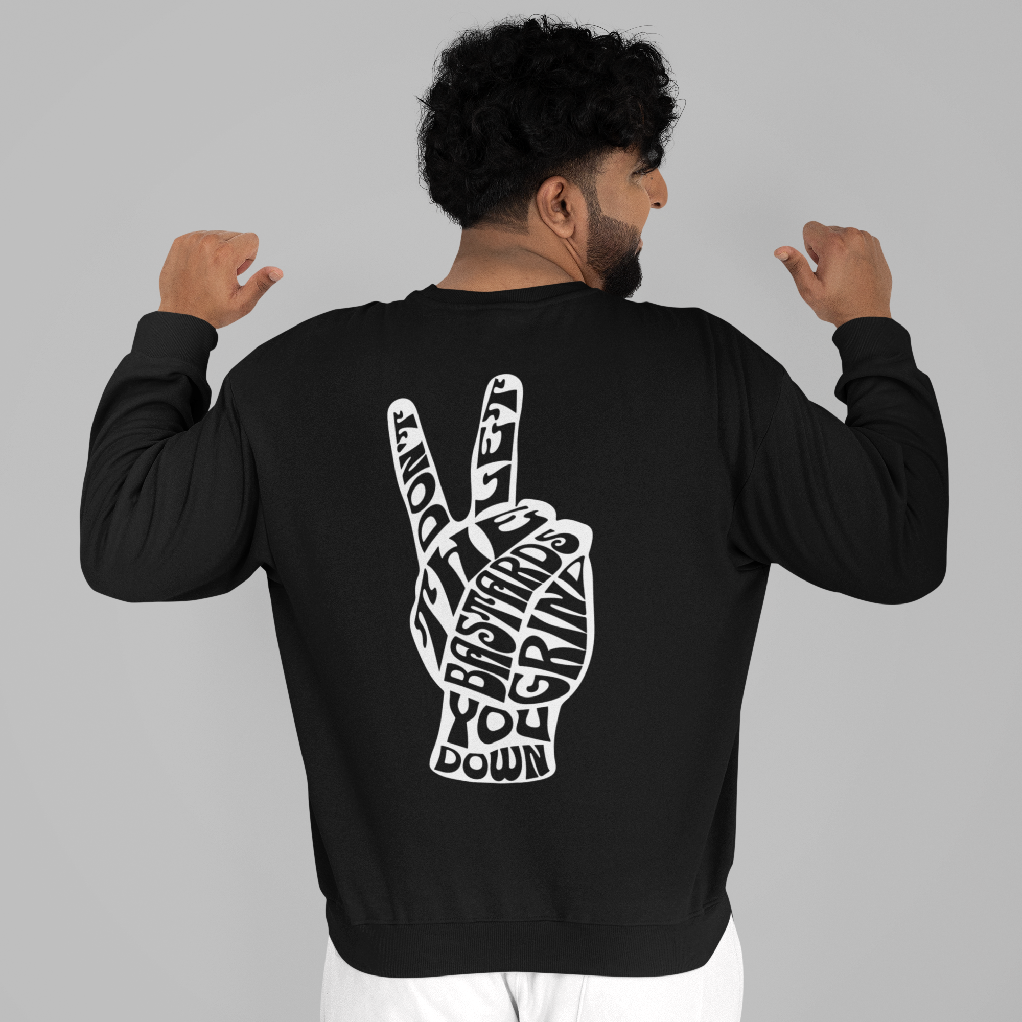 Person wearing a black sweatshirt with a white graphic on the back, standing against a gray background