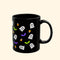 Black mug with Halloween-themed designs on a white background