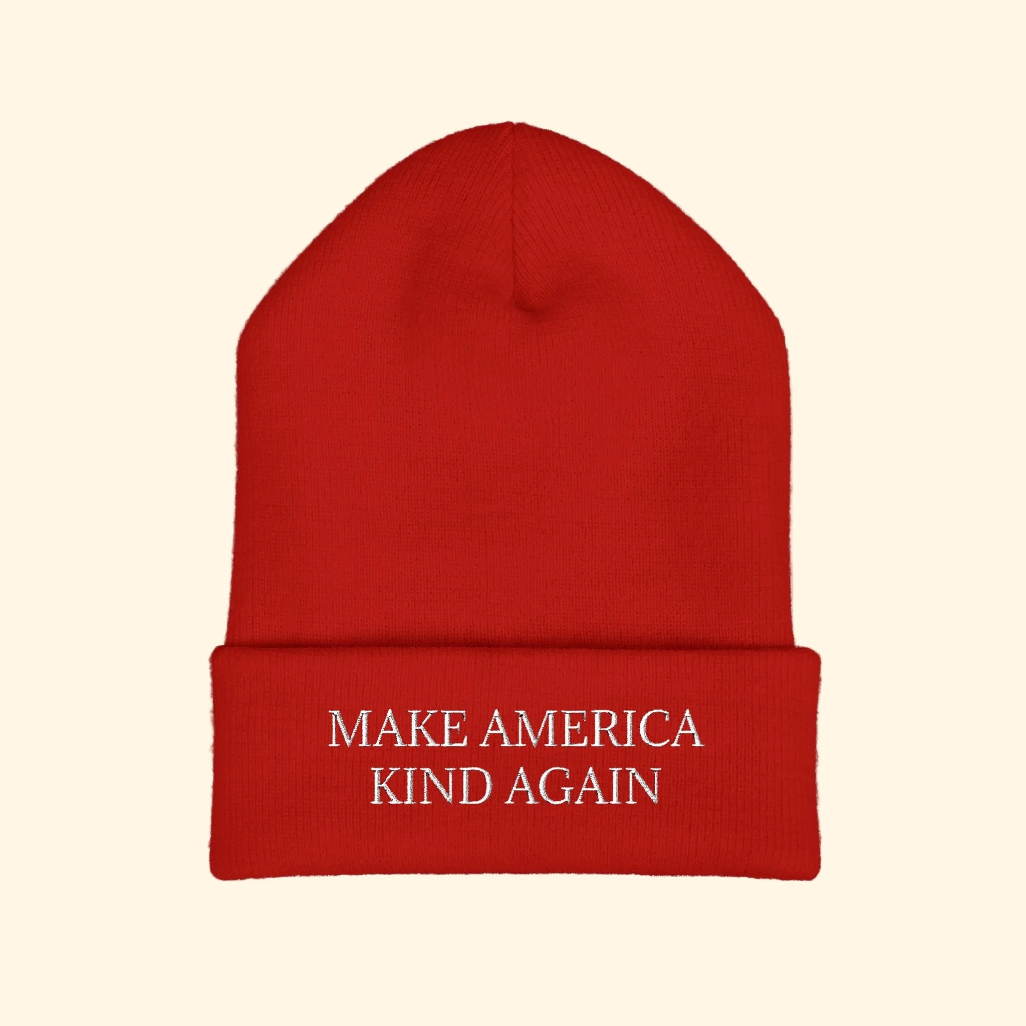 Red beanie with 'Make America Kind Again' text on a white background