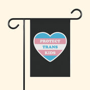 Flag with a heart design and text 'PROTECT TRANS KIDS' on a black background